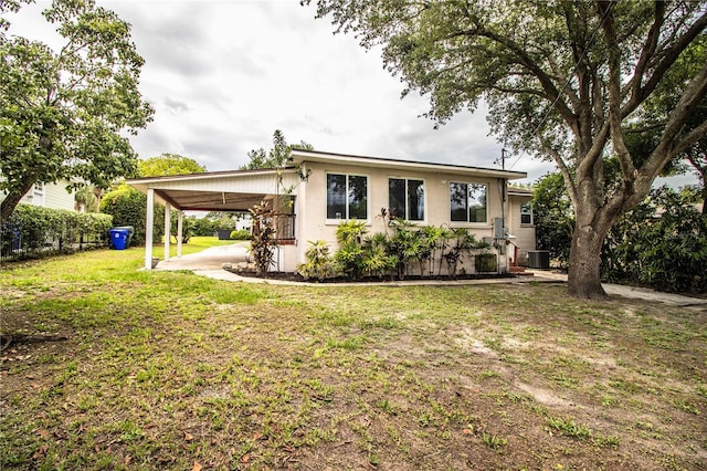 2710 Fairmount Ave, Lakeland, FL 33803 - back of house featuring an attached carport, a yard, stucco siding, and central air condition unit
