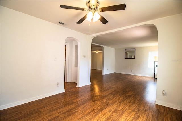 2710 Fairmount Ave, Lakeland, FL 33803 - empty room with ceiling fan, arched walkways, dark wood finished floors, and baseboards