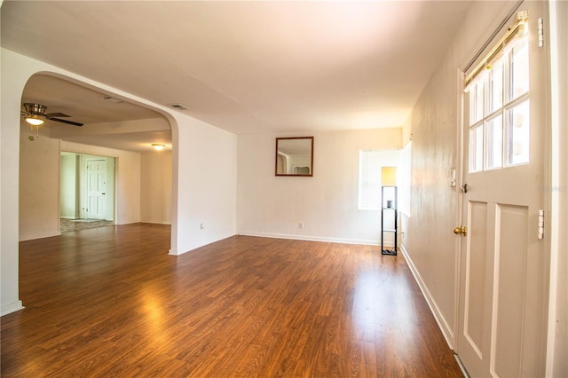 2710 Fairmount Ave, Lakeland, FL 33803 - spare room featuring arched walkways, dark wood-style flooring, ceiling fan, and baseboards