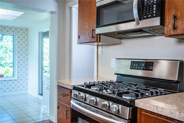 2710 Fairmount Ave, Lakeland, FL 33803 - kitchen with appliances with stainless steel finishes, wallpapered walls, light countertops, baseboards, and plenty of natural light