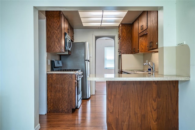 2710 Fairmount Ave, Lakeland, FL 33803 - kitchen featuring stainless steel appliances, dark wood finished floors, light countertops, a sink, and a peninsula