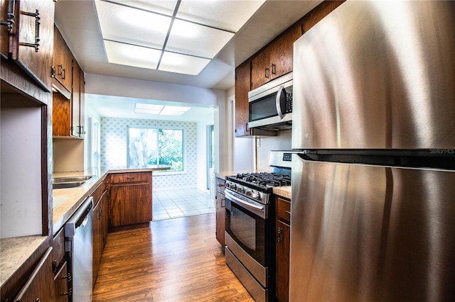 2710 Fairmount Ave, Lakeland, FL 33803 - kitchen featuring stainless steel appliances, light countertops, dark wood-style floors, and a peninsula