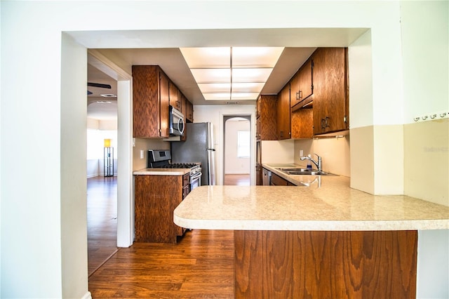 2710 Fairmount Ave, Lakeland, FL 33803 - kitchen with stainless steel appliances, dark wood-type flooring, arched walkways, a sink, and light countertops