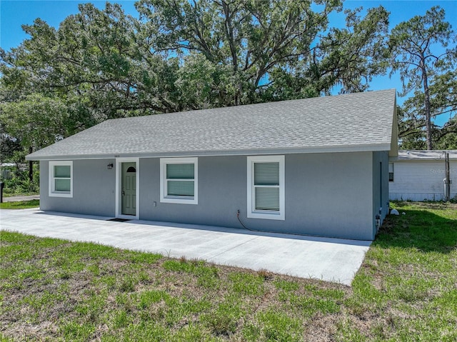 1415 Southern Ave, Lakeland, FL 33803 - ranch-style home featuring roof with shingles, stucco siding, a front yard, and a patio