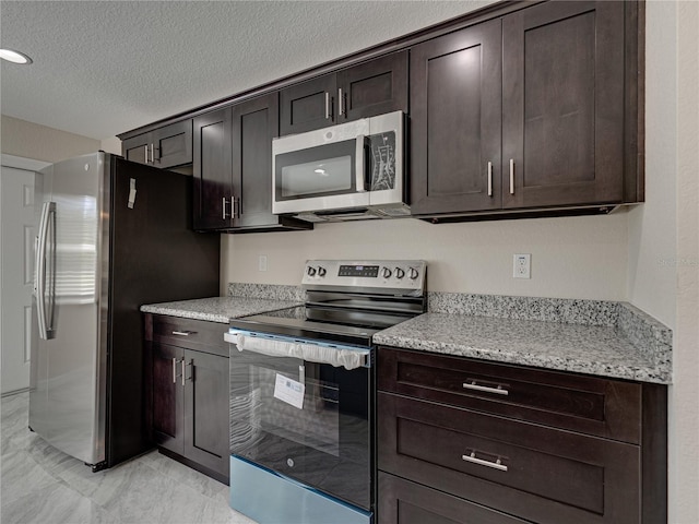 1415 Southern Ave, Lakeland, FL 33803 - kitchen with appliances with stainless steel finishes, dark brown cabinets, light marble finish flooring, and a textured ceiling