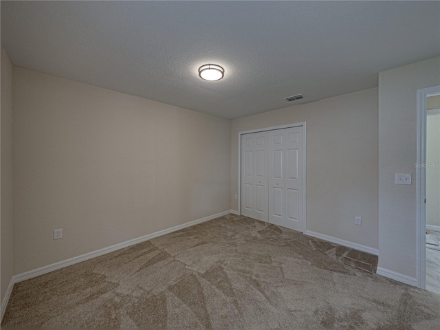 1415 Southern Ave, Lakeland, FL 33803 - unfurnished bedroom with carpet floors, a closet, baseboards, and a textured ceiling