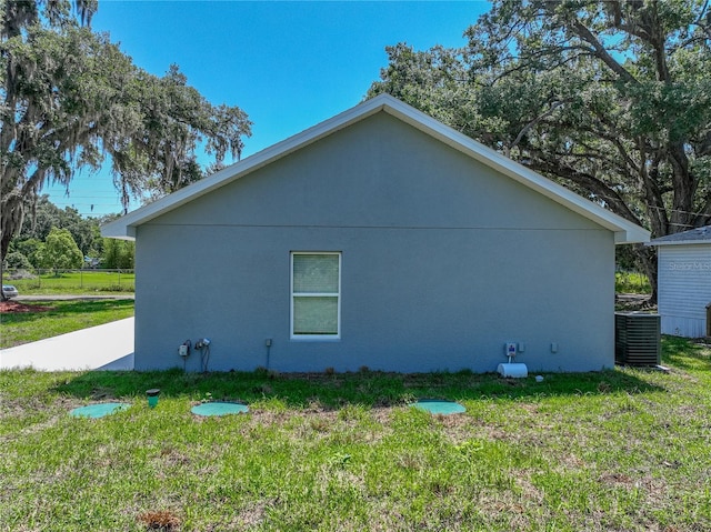 1415 Southern Ave, Lakeland, FL 33803 - view of home's exterior featuring a lawn, stucco siding, and central AC