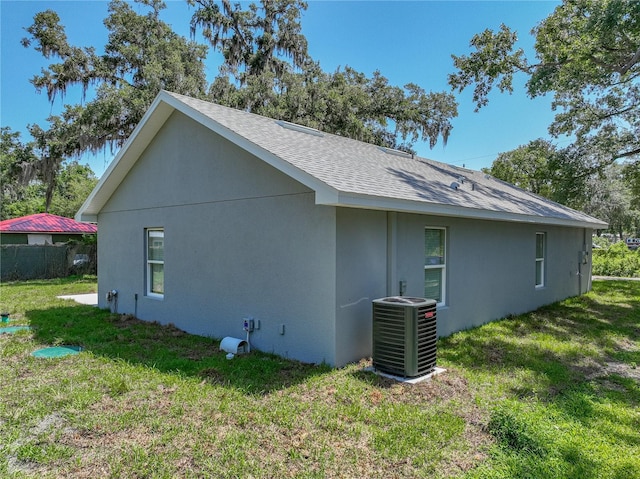1415 Southern Ave, Lakeland, FL 33803 - view of property exterior with cooling unit, a shingled roof, a yard, and stucco siding