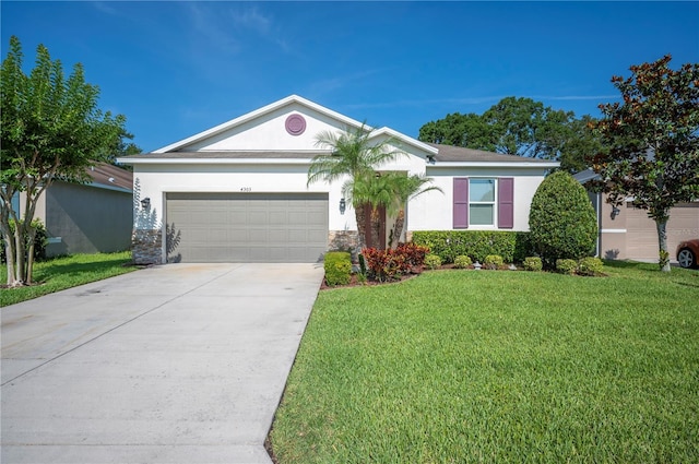 4303 Moon Shadow Loop, Mulberry, FL 33860 - ranch-style house with an attached garage, stucco siding, concrete driveway, a front lawn, and stone siding