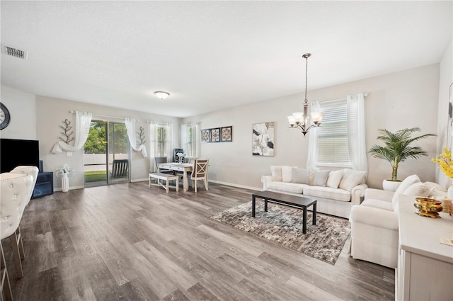 4303 Moon Shadow Loop, Mulberry, FL 33860 - living room featuring wood finished floors, a chandelier, and baseboards