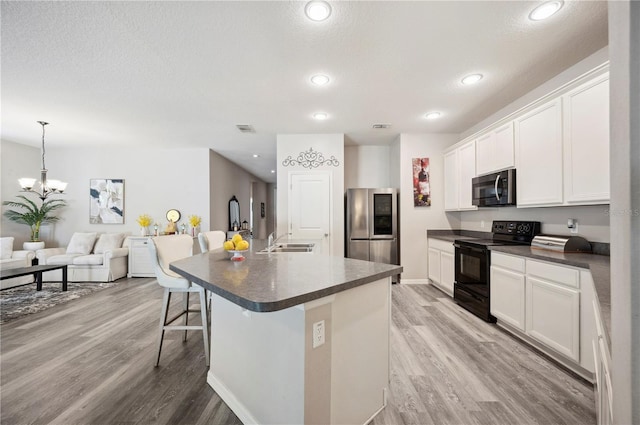 4303 Moon Shadow Loop, Mulberry, FL 33860 - kitchen with stainless steel appliances, dark countertops, light wood-type flooring, a sink, and recessed lighting