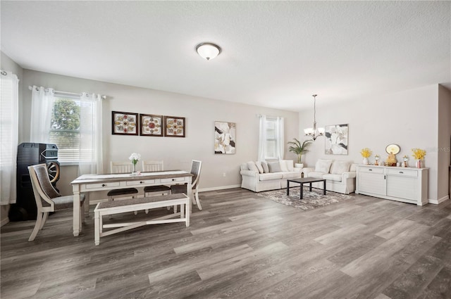 4303 Moon Shadow Loop, Mulberry, FL 33860 - dining space with a chandelier, wood finished floors, baseboards, and a textured ceiling
