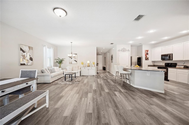 4303 Moon Shadow Loop, Mulberry, FL 33860 - living room featuring wood finished floors, a chandelier, and recessed lighting