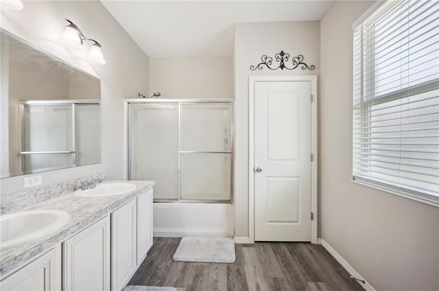 4303 Moon Shadow Loop, Mulberry, FL 33860 - full bathroom featuring wood finished floors, double vanity, enclosed tub / shower combo, and baseboards