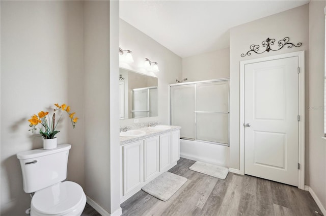 4303 Moon Shadow Loop, Mulberry, FL 33860 - bathroom with wood finished floors, toilet, double vanity, baseboards, and shower / bath combination with glass door