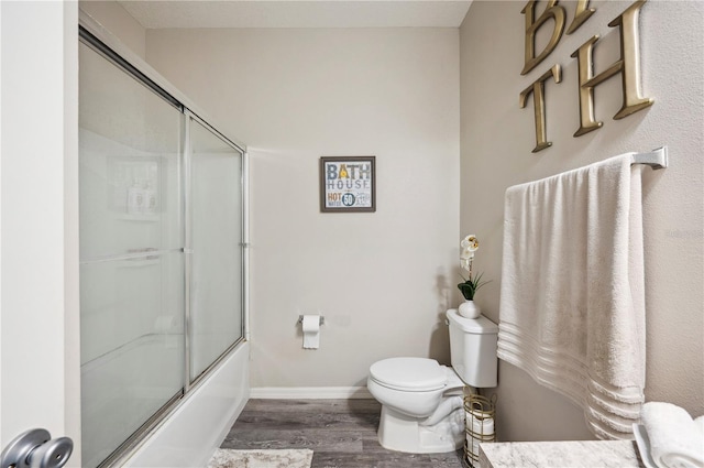 4303 Moon Shadow Loop, Mulberry, FL 33860 - bathroom featuring toilet, wood finished floors, enclosed tub / shower combo, and baseboards