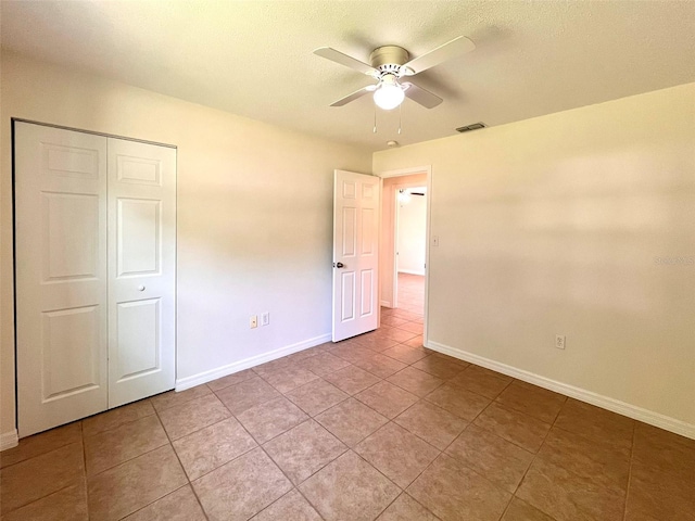 2323 Ridgeview Dr, Lakeland, FL 33810 - unfurnished bedroom featuring baseboards, light tile patterned floors, a closet, and ceiling fan