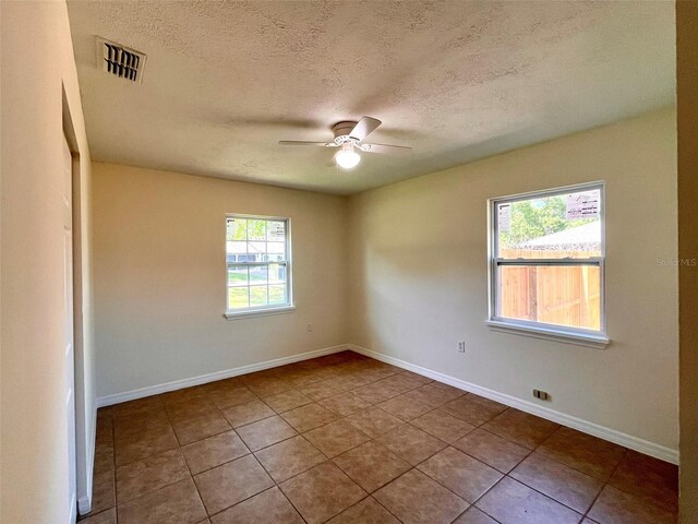 2323 Ridgeview Dr, Lakeland, FL 33810 - tiled spare room with ceiling fan, a textured ceiling, and baseboards