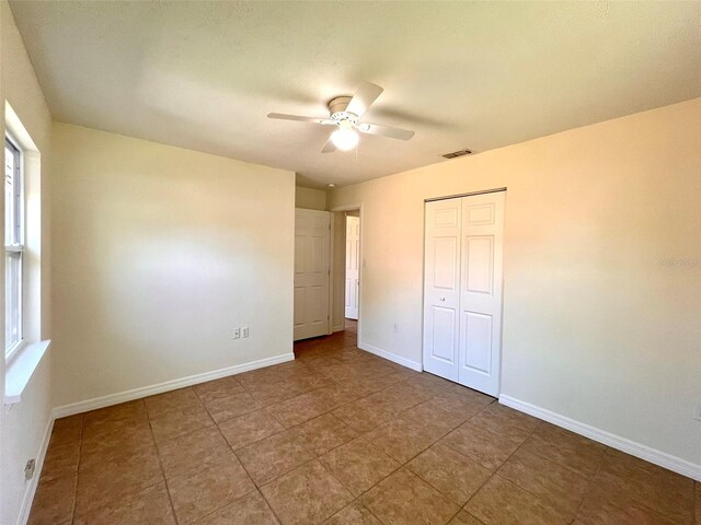 2323 Ridgeview Dr, Lakeland, FL 33810 - unfurnished bedroom with baseboards, a closet, a ceiling fan, and tile patterned floors