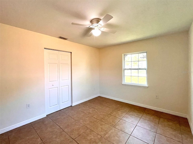 2323 Ridgeview Dr, Lakeland, FL 33810 - unfurnished bedroom with baseboards, a closet, tile patterned flooring, and a ceiling fan