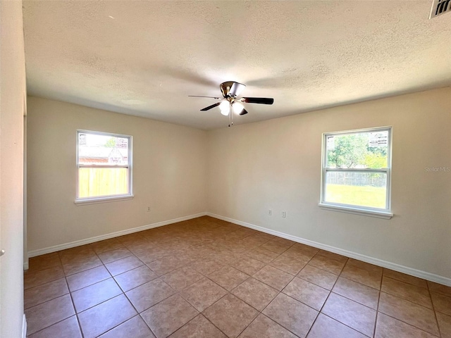 2323 Ridgeview Dr, Lakeland, FL 33810 - empty room featuring plenty of natural light, tile patterned floors, ceiling fan, a textured ceiling, and baseboards