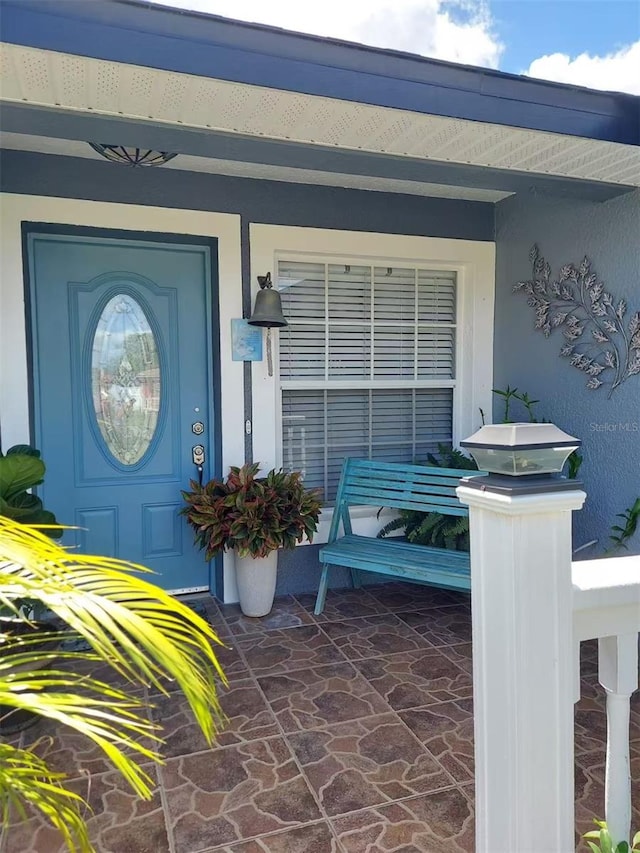 455 Eagle Dr, Kissimmee, FL 34759 - view of exterior entry with covered porch and stucco siding