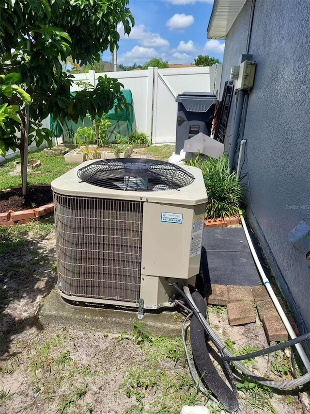 455 Eagle Dr, Kissimmee, FL 34759 - exterior view of central AC unit, fence, and stucco siding