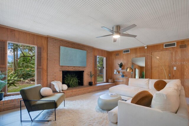 312 Palencia Pl, Lakeland, FL 33803 - living room featuring wooden walls, ceiling fan, and a brick fireplace
