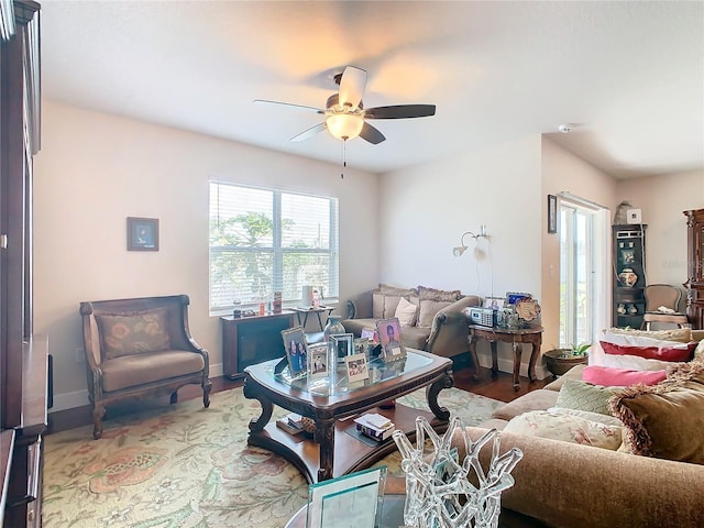 living room featuring ceiling fan, wood finished floors, and baseboards