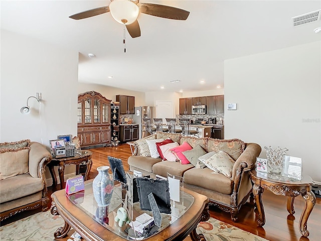living area with light wood-style flooring, a ceiling fan, and recessed lighting