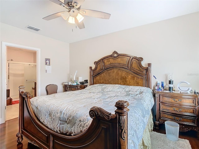 bedroom with dark wood finished floors, ceiling fan, and connected bathroom