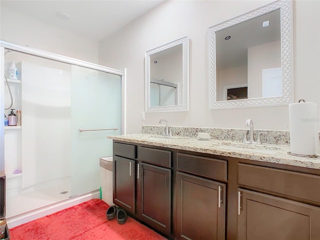 bathroom with a shower stall and double vanity