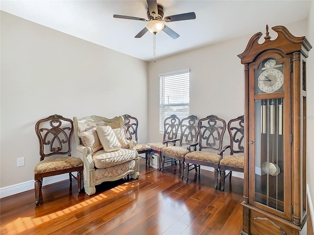sitting room with ceiling fan, dark wood-style floors, and baseboards