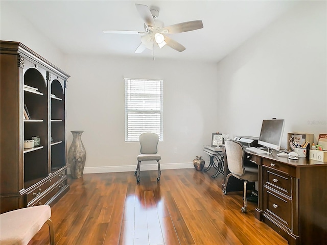 office area with dark wood-style flooring, ceiling fan, and baseboards