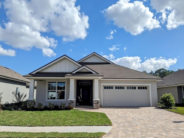 7919 Lake James Blvd, Lakeland, FL 33810 - craftsman house with an attached garage, decorative driveway, a front lawn, and board and batten siding