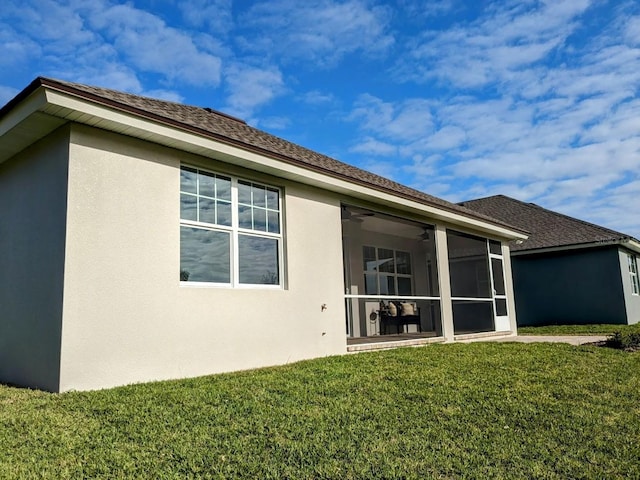 7919 Lake James Blvd, Lakeland, FL 33810 - rear view of house with stucco siding, a yard, a sunroom, and a ceiling fan