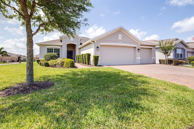 3136 Langdon Ln, Winter Haven, FL 33884 - ranch-style house featuring stucco siding, decorative driveway, a garage, and a front lawn