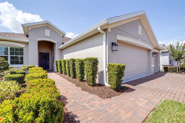 3136 Langdon Ln, Winter Haven, FL 33884 - view of front facade featuring stucco siding, a garage, and decorative driveway