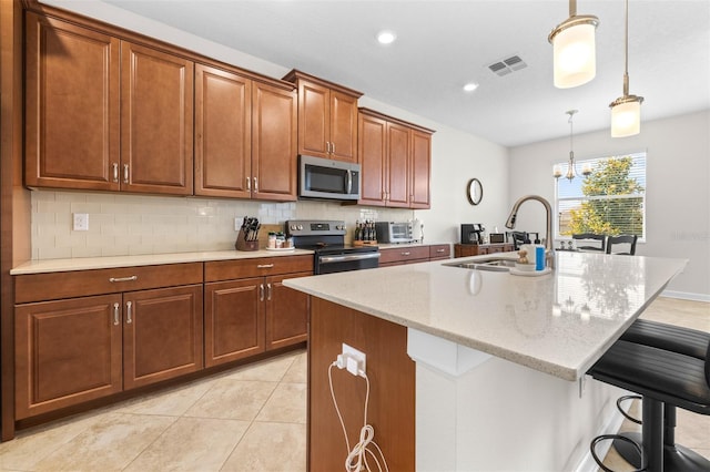 3136 Langdon Ln, Winter Haven, FL 33884 - kitchen with stainless steel appliances, a sink, a breakfast bar area, backsplash, and brown cabinetry