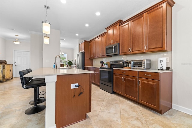 3136 Langdon Ln, Winter Haven, FL 33884 - kitchen with stainless steel appliances, a sink, a kitchen bar, light countertops, and a kitchen island with sink