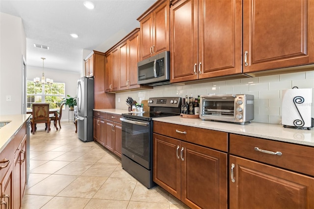 3136 Langdon Ln, Winter Haven, FL 33884 - kitchen featuring appliances with stainless steel finishes, backsplash, light tile patterned floors, a chandelier, and recessed lighting