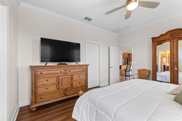 3136 Langdon Ln, Winter Haven, FL 33884 - bedroom with dark wood finished floors, ornamental molding, freestanding refrigerator, baseboards, and ceiling fan