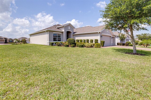 3136 Langdon Ln, Winter Haven, FL 33884 - ranch-style home with stucco siding, a garage, a front lawn, and driveway