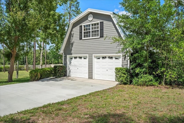 9912 Pine Leaf Ln, Dade City, FL 33525 - view of property exterior with a gambrel roof, driveway, and a garage