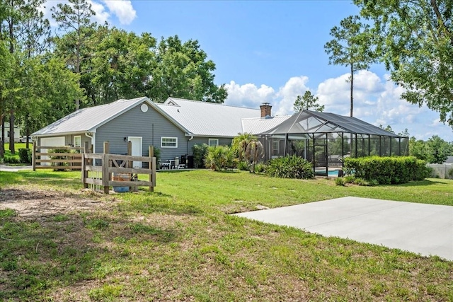 9912 Pine Leaf Ln, Dade City, FL 33525 - rear view of property featuring a chimney, metal roof, glass enclosure, and an outdoor pool