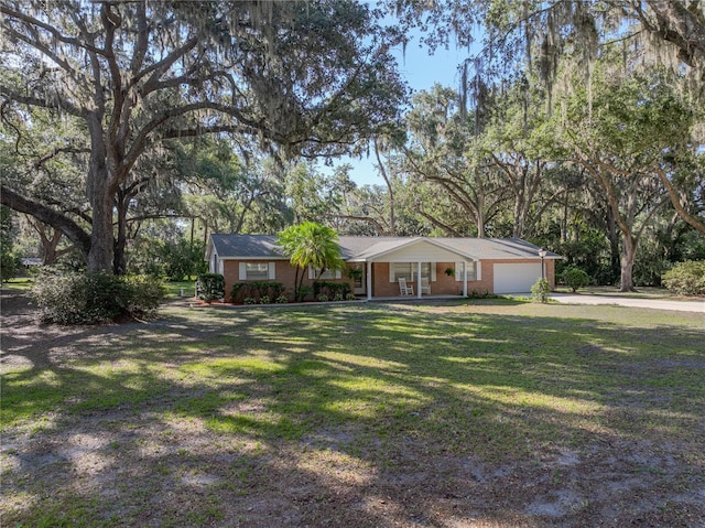 ranch-style home featuring a front yard, a porch, concrete driveway, a garage, and brick siding