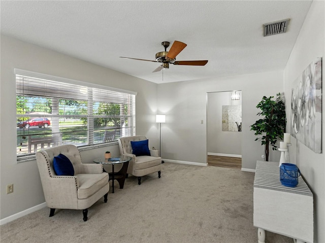 sitting room with a ceiling fan, carpet flooring, and baseboards