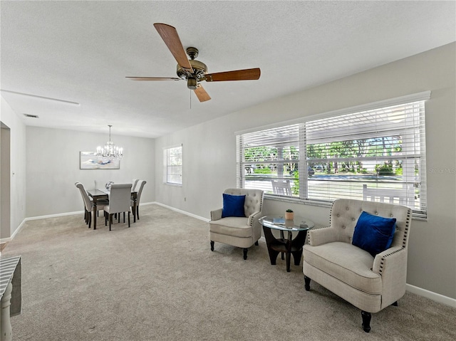 living area with carpet, a chandelier, ceiling fan, and baseboards