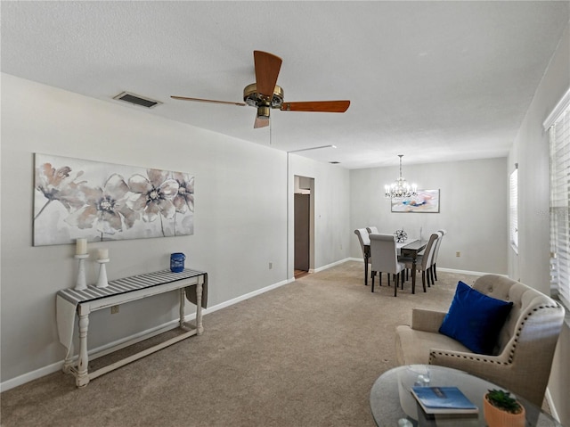 living room with a chandelier, carpet, a ceiling fan, and baseboards
