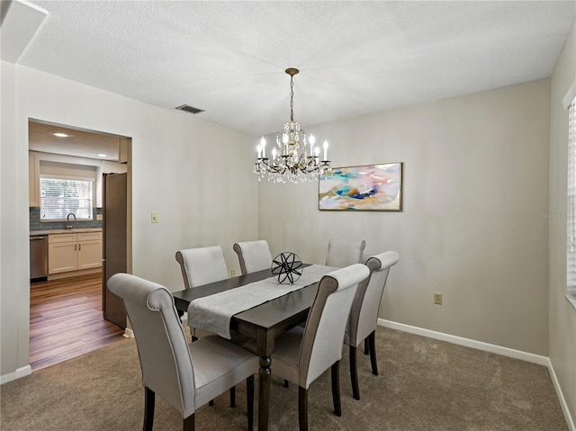 dining area with dark carpet, a chandelier, baseboards, and a textured ceiling